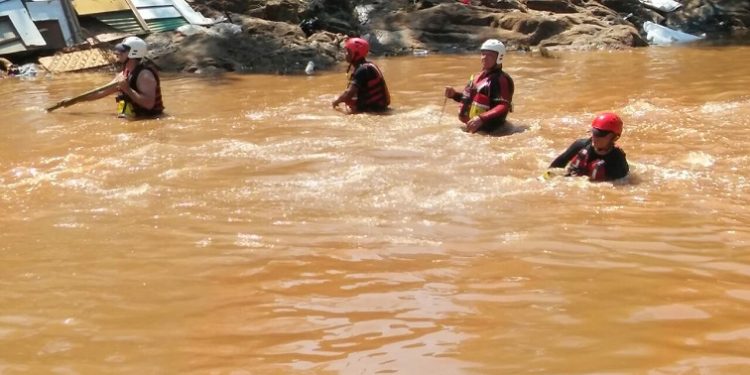 Rescue workers are seen at the Jukskei river in search of missing bodies.